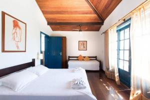 布希奥斯Casa do canto的一间卧室设有两张床和大窗户