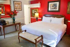 米德派恩斯优胜美地布格乡村避暑山庄酒店的卧室设有红色的墙壁、白色的床和桌子