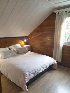 萨拉济Porte de Mafate - Grand Ilet的卧室配有一张白色大床和木墙