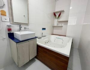 麦德林Hotel Sixtina Plaza Medellin的白色的浴室设有浴缸和水槽。
