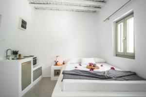 DexamenesArmonia Guesthouse close to Mykonos town的白色的卧室设有床和窗户