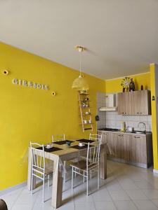 圣维托罗卡波Appartamento Girasole的厨房设有黄色的墙壁和桌椅