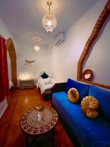 舍夫沙万Riad Bab Mahruk的客厅配有蓝色的沙发和桌子