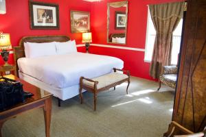 米德派恩斯优胜美地布格乡村避暑山庄酒店的红色卧室配有白色的床和椅子