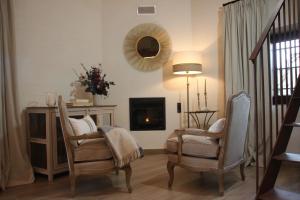 Horcajuelo de la SierraHOTEL RURAL SANTUI的客厅配有两把椅子和壁炉