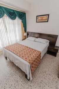 蒙特里亚Casa Hotel Miriam的一间卧室设有一张大床和一个窗户。