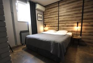 大戈里察Rooms Kaktus的一间卧室设有一张床和木墙