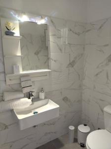 卡托克拉克阿纳Digkas Apartments的白色的浴室设有水槽和镜子