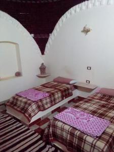 Mandīshahoasis panorama的白色客房内的两张床,配有两张sidx sidx sidx床