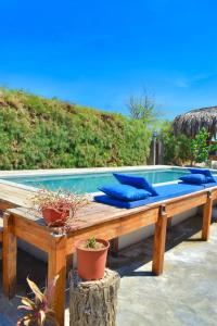 维加伊托Casa Lodge (primera fila)的木制长凳上的带蓝色枕头的游泳池