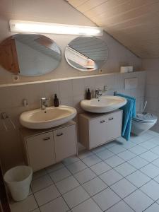 雷宁根L8 Street Apartments - Renningen的浴室设有2个水槽和2面镜子