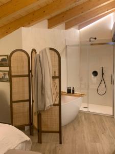 Horcajuelo de la SierraHOTEL RURAL SANTUI的一间卧室设有1间带浴缸和淋浴的浴室