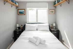 伦敦Kennington 3BR Haven: Dog-Friendly/Central London的卧室配有白色的床和2条毛巾