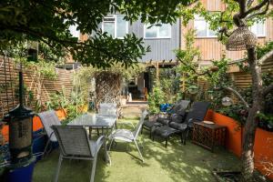 伦敦Kennington 3BR Haven: Dog-Friendly/Central London的一个带椅子和桌子的庭院和一棵树