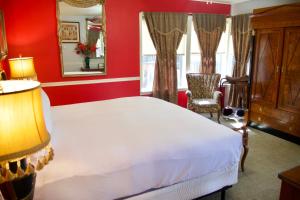 米德派恩斯优胜美地布格乡村避暑山庄酒店的卧室配有白色的床和红色的墙壁