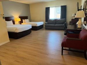 诺加利斯Hotel Americana的酒店客房,设有两张床和一张沙发
