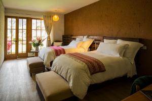 库斯科Lamay Lodge的一间卧室设有两张床和窗户。