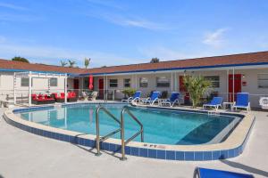 圣徒皮特海滩Sun Island Motel的一座带椅子的酒店游泳池以及一座建筑