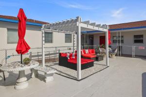 圣徒皮特海滩Sun Island Motel的露台的凉亭配有红色家具