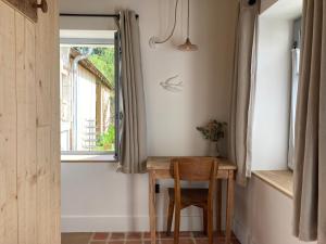 阿姆博斯Maison Chemin, chambres d'hôtes à Amboise的窗户房间里的小桌子