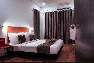 SohnaSPOT ON Royal Residency的一间卧室配有一张床、一张桌子和一个窗户。