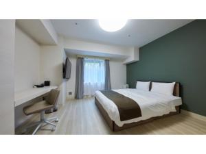 厚木Rembrandt Hotel Atsugi - Vacation STAY 41674v的一间卧室配有一张床、一张桌子和一把椅子