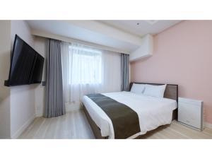 厚木Rembrandt Hotel Atsugi - Vacation STAY 41674v的配有一张床和一台平面电视的酒店客房