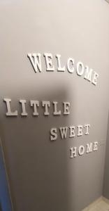 佩罗Little Sweet Home - Fiera Milano的墙上有欢迎小飞快回家的标志