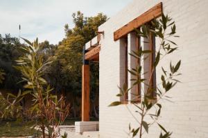 法尤姆Tzila Lodge的白色砖砌建筑,设有木制凉棚