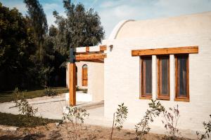 法尤姆Tzila Lodge的白色房子的侧面设有木窗