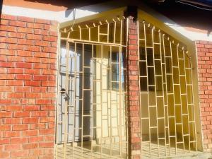 BushenyiLuxury studio apartment by Hope的砖墙上有一扇金条门