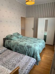 敦刻尔克l'Éclat du Littoral Vue mer - Good Home的一间卧室配有两张床和一张床套