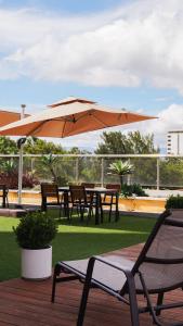 危地马拉Hotel Vista Quince的甲板上配有桌椅和遮阳伞