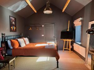 莫克姆The Balmoral Coach House的一间卧室配有一张床和一台电视。