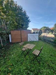 克莱蒙费朗Le Guichard - Wifi - Parking - Terrasse的院子里的一张野餐桌和两把椅子