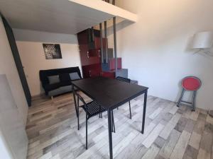 克莱蒙费朗Le Guichard - Wifi - Parking - Terrasse的客厅配有一张黑桌子和椅子