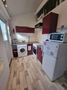 克莱蒙费朗Le Guichard - Wifi - Parking - Terrasse的一间配备了红色橱柜和白色家电的小厨房