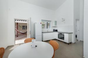 克拉伦代克Casita Palma的白色的厨房配有白色的桌子和椅子