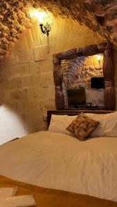 尚勒乌尔法karagül otel的一间卧室配有一张带木制床头板的床