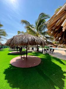 Los SantosParadise Resort的公园里大草伞,配有桌椅