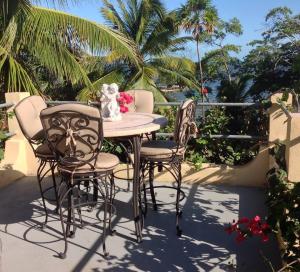 White HillMermaid Manor Belize的棕榈树庭院内的桌椅
