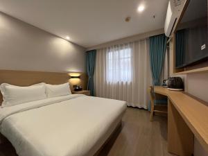 广州布丁酒店（广州洛溪地铁站店)的酒店客房设有一张大床和一张书桌。