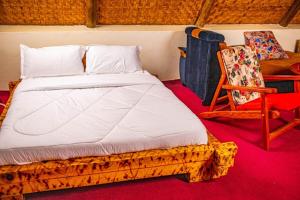 贝塔Bugoma Sand Beach and Resort Hotel的房间里的一张床和椅子