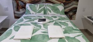 丹地Dundee Viks Guest House的一张带绿色和白色棉被和枕头的床