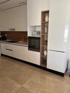 ArkouVilla ZwinA的厨房配有白色橱柜和炉灶。