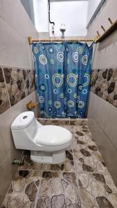 莫姆皮切Casa Gaia: Un Paraiso的浴室设有卫生间和蓝色的浴帘