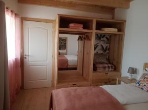 OuzendaCasa Virginia的一间卧室配有带镜子的衣柜和一张床