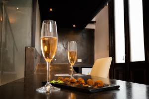 布宜诺斯艾利斯Loft Osteria by Sagardi的两杯酒和一盘桌上的食物