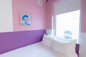纳什维尔The Gallatin的粉红色的客房设有床和窗户。