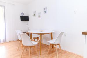 索科矿泉村Apartmani Zvirac的一间带桌子和白色椅子的用餐室